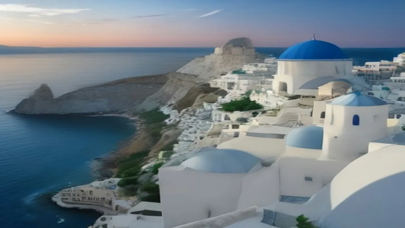 Whitewashed houses and blue domes on a Greek island cliff above the sea at sunset