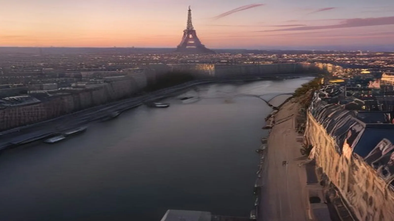 The Eiffel Tower on the skyline at dusk above the Seine and the rooftops of Paris