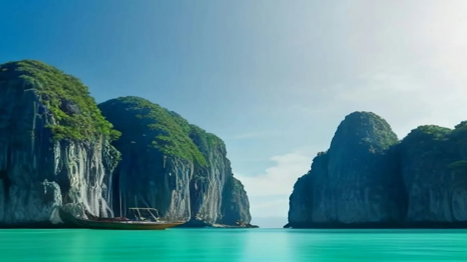 Limestone cliffs rising from a turquoise lagoon, with a wooden outrigger boat at their base