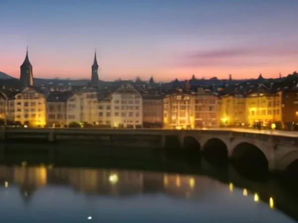 Church spires and old houses along a river at dusk